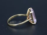 a close up of a gold ring with an amethorate stone