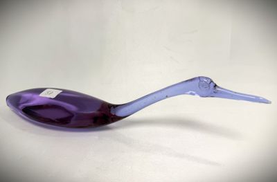 a purple spoon with a long handle sitting on a white surface
