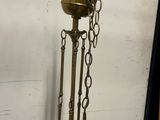 a brass clock with chains hanging from it ' s sides