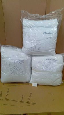 four bags of white pillows on top of a cardboard box