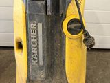 yellow and black machine sitting in a garage next to a garage door