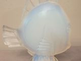 a glass fish sculpture on a table with a white background