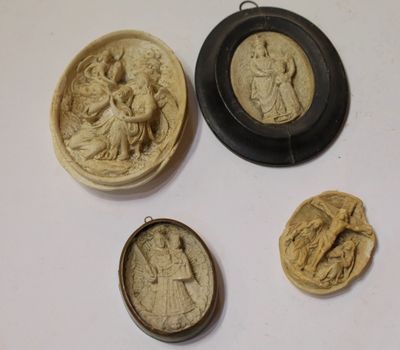 trois petits camées sculptés représentant des femmes et des hommes, dans un cadre noir