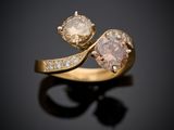 un gros plan d'une bague en or sertie de deux diamants sur un fond noir