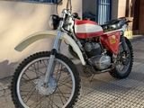 a red and white dirt bike parked on the side of the street