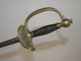 a close up of a sword on a white surface