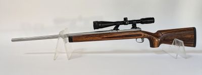 un gros plan d'un fusil équipé d'une lunette de visée sur fond blanc