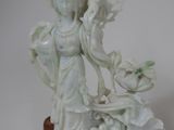 a statue of a woman holding a bird on a table