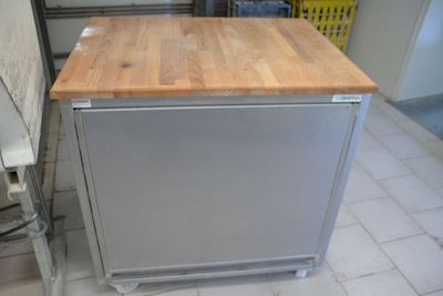 a silver dishwasher sitting on top of a wooden counter