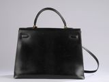 a black handbag sitting on top of a white table