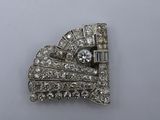 a close up of a diamond broochle on a white surface