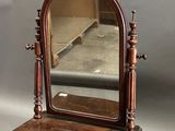 une coiffeuse ancienne en bois surmontée d'un miroir