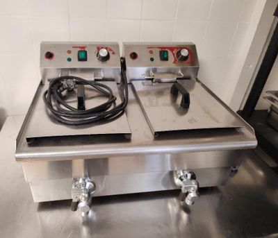 deux friteuses électriques posées sur un plan de travail en inox
