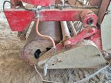 une machine rouge qui est à l'arrêt dans la poussière