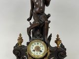 une statue représentant un garçon assis au sommet d'une horloge