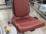 a red chair sitting next to a machine in a gym