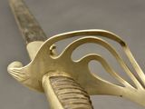 a close up of a sword with a gold handle