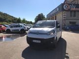 une camionnette blanche garée devant un bâtiment dans un parking