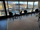tables and chairs in a restaurant with a view of the mountains