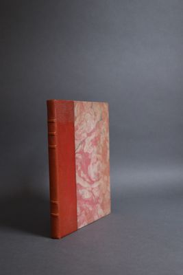 a red book sitting on top of a gray surface