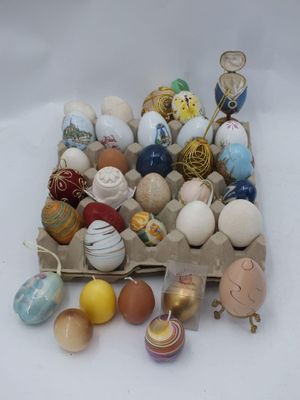 de nombreux œufs de différentes couleurs dans une boîte posée sur la table