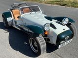 une voiture de sport verte et blanche garée sur le bord de la route