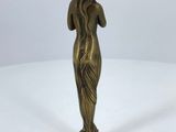 a bronze statue of a woman holding a flower in her hand