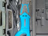 a blue electric tool in a case on the ground