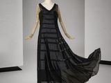 une photo d'un mannequin portant une robe noire dans une pièce blanche