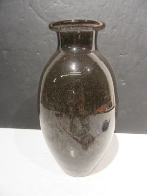 a brown vase sitting on a white table