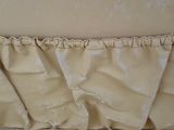 a close up view of a bed with a ruffled cover