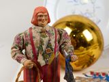 a figurine of a woman with a basket of money next to a plate