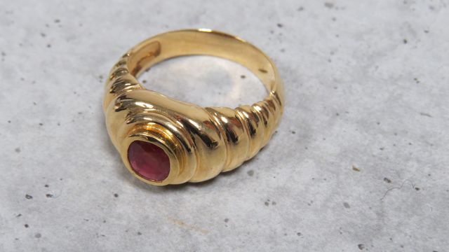 Bague en or jaune 750 millièmes ornée au centre d'une pierre roug...