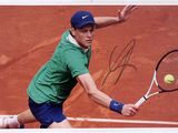 signed photo of a tennis player hitting a tennis ball with a racquet