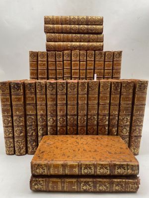 several old books stacked on top of each other on a white surface