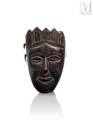 une image représentant un masque en bois surmonté d'une couronne