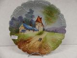 a decorative plate with a painting of a farm scene on it
