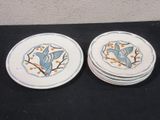two plates with birds on them sitting on a table