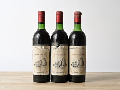 three bottles of wine sitting on top of a wooden table