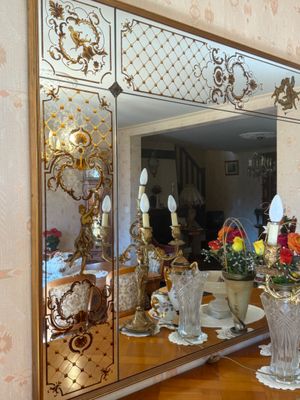 a mirror on a table with a vase of flowers on it