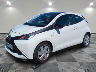 une Toyota AY blanche garée dans une pièce au sol carrelé