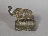 statue d'un éléphant posé sur un rocher, avec un oiseau sur son dos