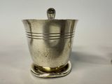 a silver ice bucket with a spoon on top of it