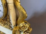 a clock that is sitting on a table with a snake on it