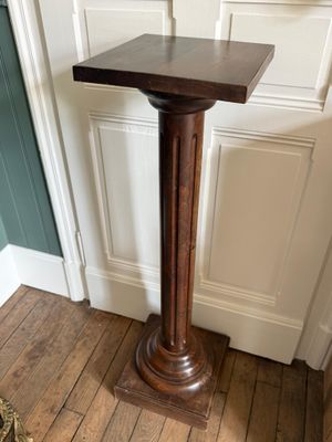 une grande table en bois sur laquelle se trouve un vase