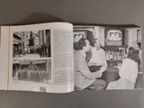 an open book with a picture of a group of people watching television