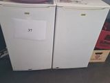 two refrigerators sitting next to each other in a room