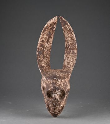 une sculpture marron représentant une tête d'animal sur une surface grise