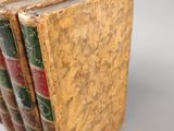 several old books are stacked on top of each other on a table