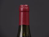 bottle of red wine on a black table with a black background